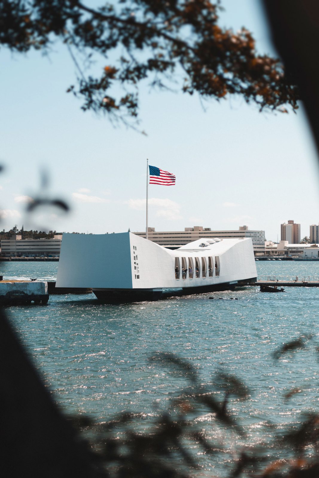 The white USS Arizona Memorial in Pearl Harbor with the American flag
