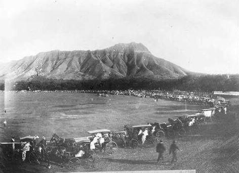 Horse-drawn carriages lined up in Kapiʻolani Park around 1900, with Diamond Head behind